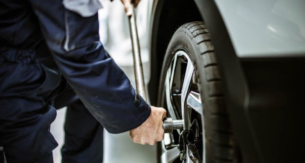 homem trocando pneu de carro